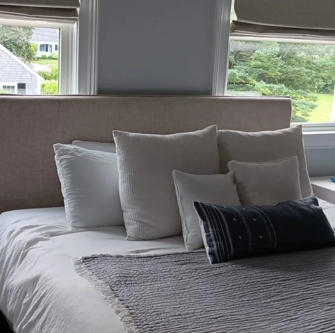 Close-up of a made bed with grey and navy pillows