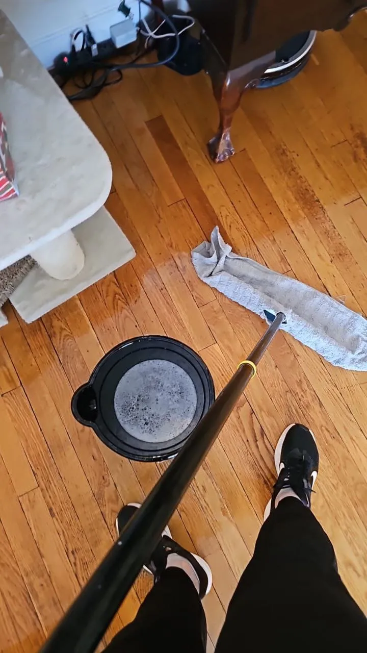 View from above of a mop and a cloth on a hardwood floor