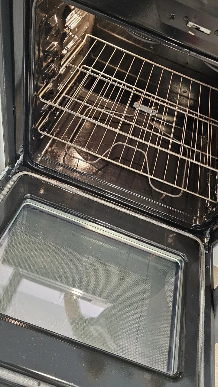 A clean oven with shiny racks and a clear glass door, after cleaning